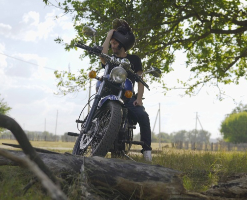 motard ajustant son casque avant de rouler en moto en été