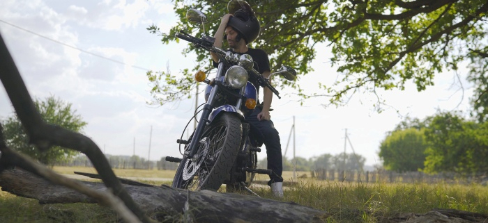 motard ajustant son casque avant de rouler en moto en été